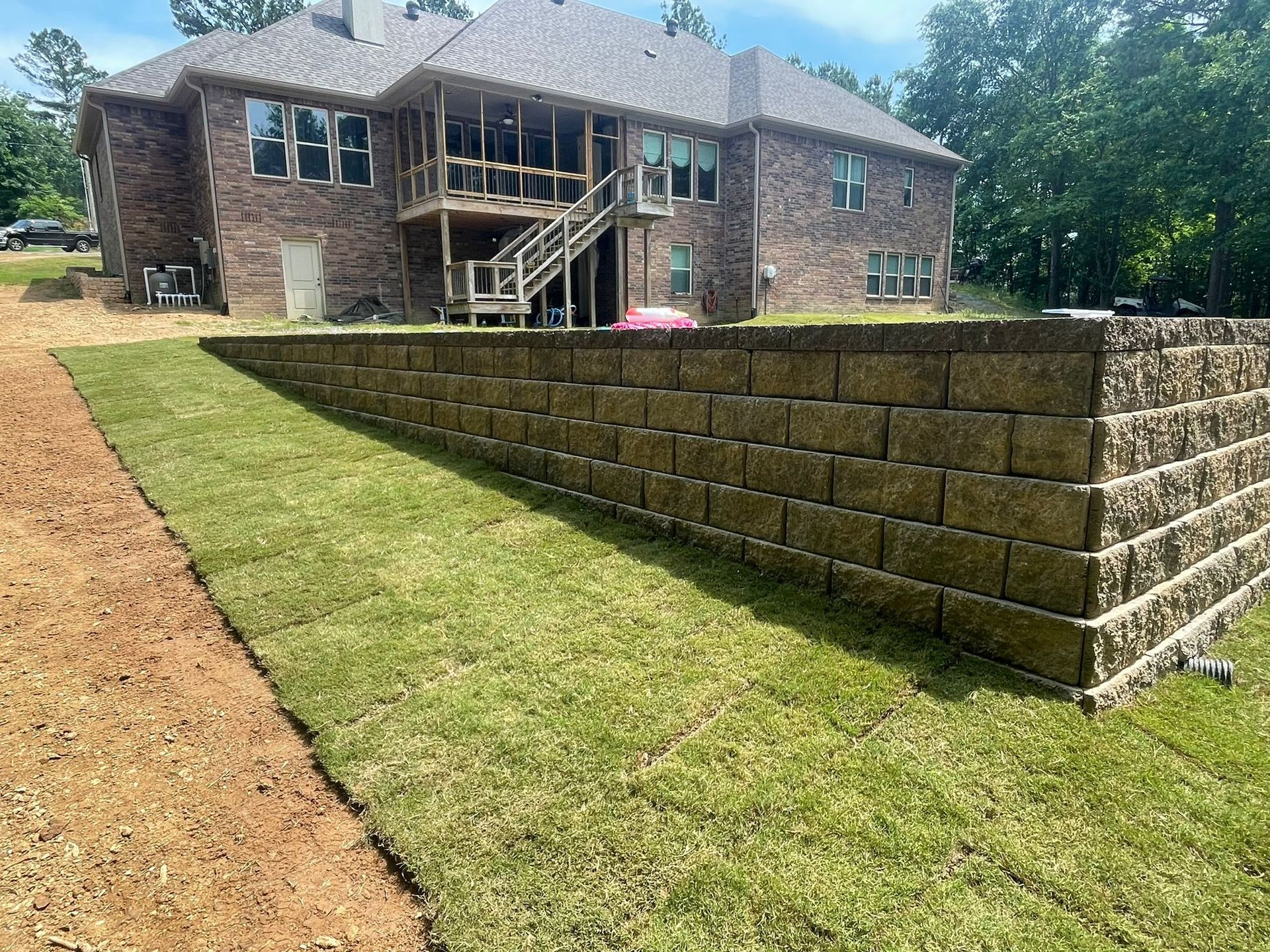 A large brick house with a brick wall in front of it.