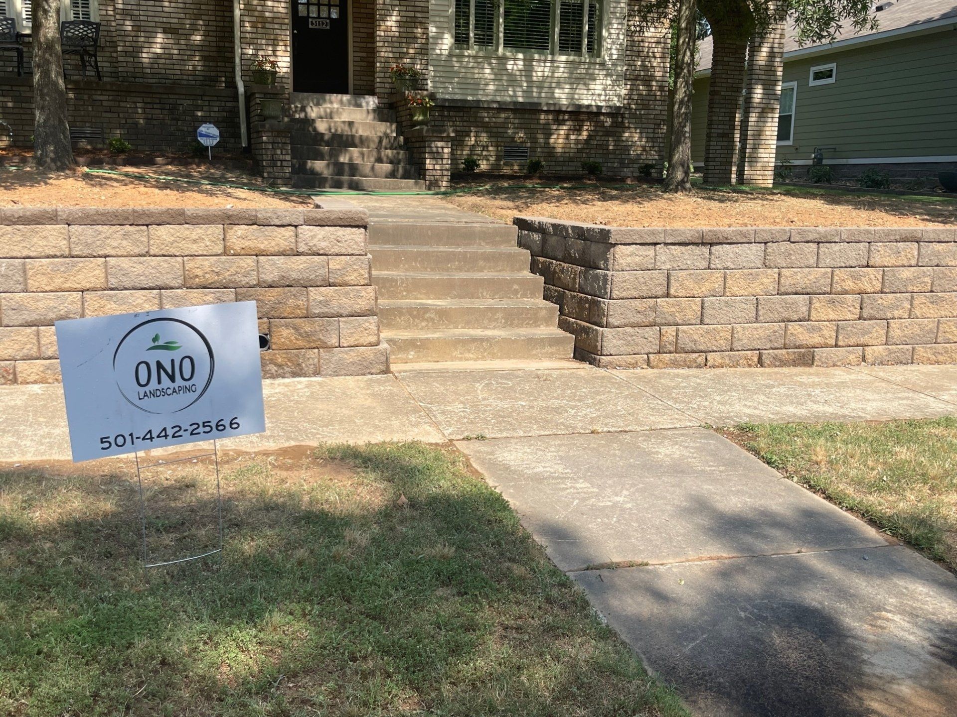 A brick wall is being built in front of a house.