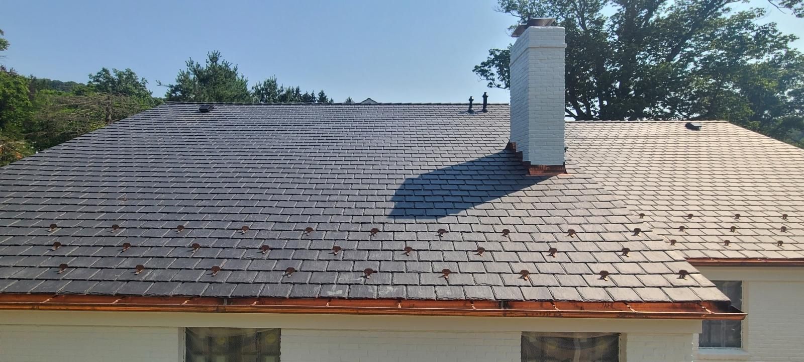 The roof of a house with a chimney on it.