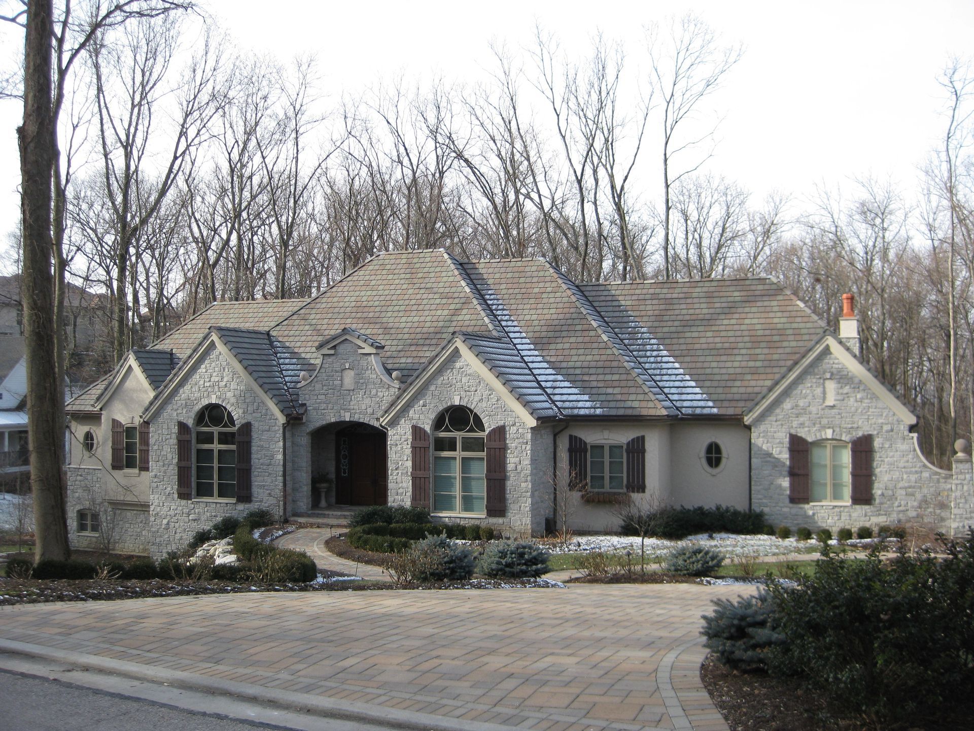 A large house with a brick driveway in front of it