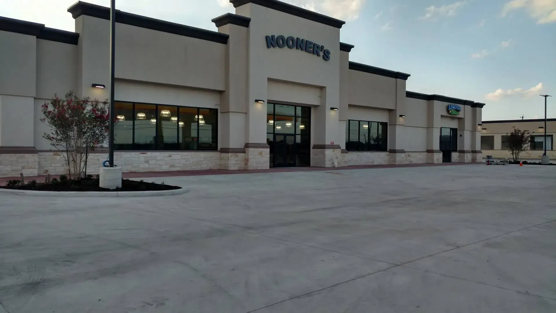 Exterior of a Woofers store with a large sign, glass windows, and a paved parking lot.