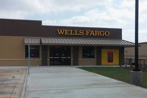 Wells Fargo bank exterior, brown and beige building with sign above the entrance, on a sunny day.