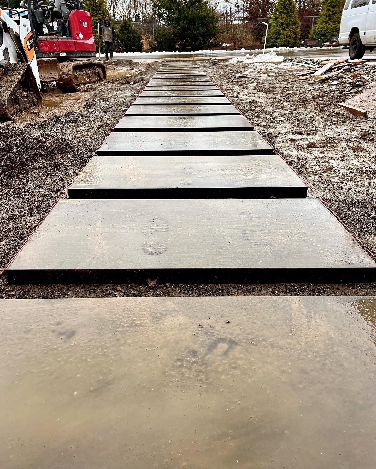 Concrete stepping stones laid in wet gravel.