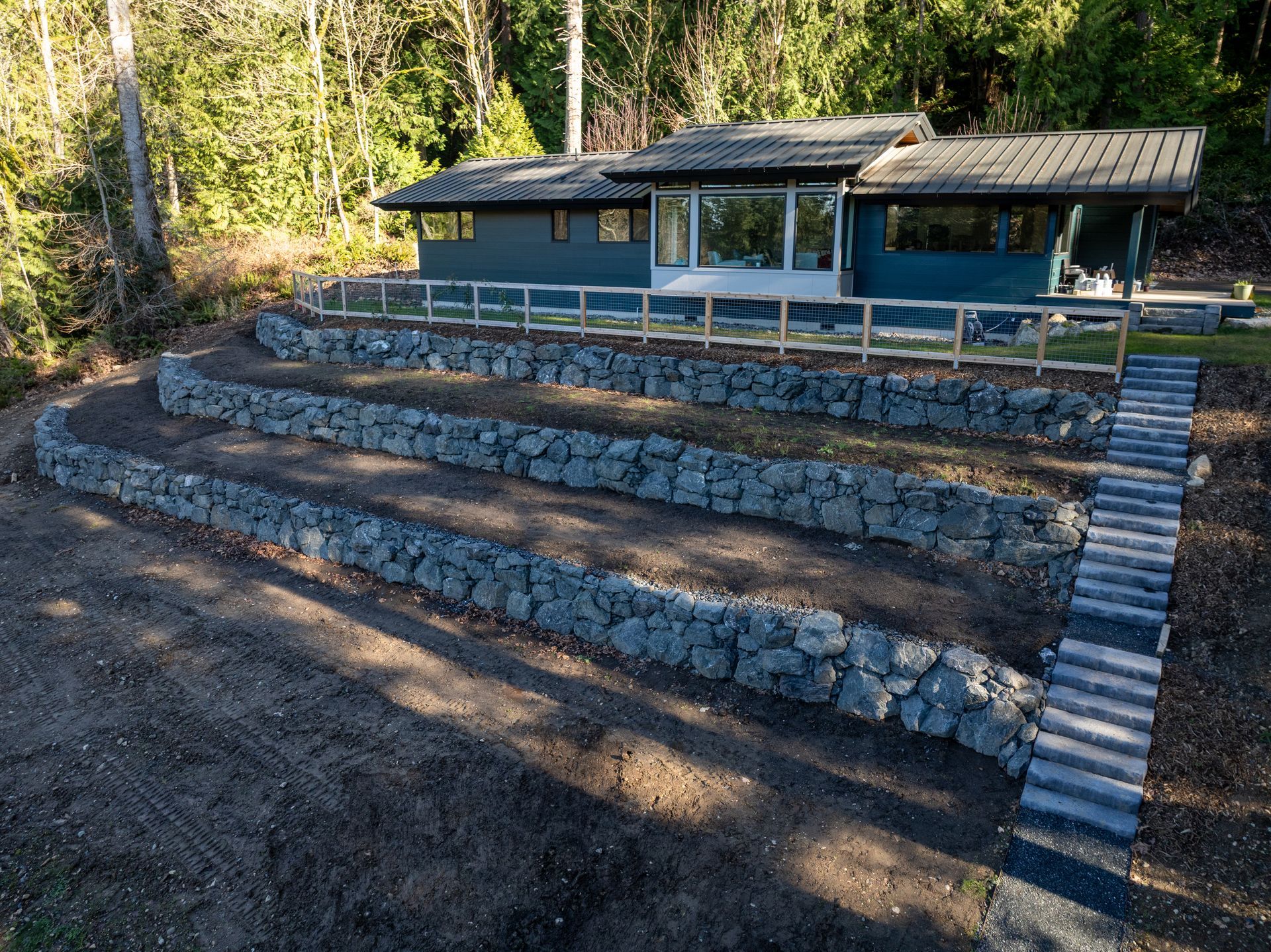 Terraced stone seating leading to a small pavilion in a wooded outdoor setting