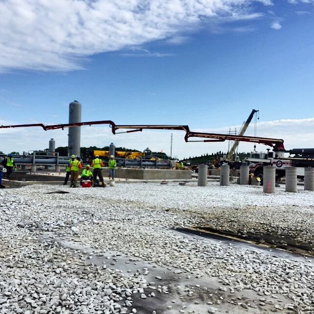 A group of construction workers are standing in a gravel area