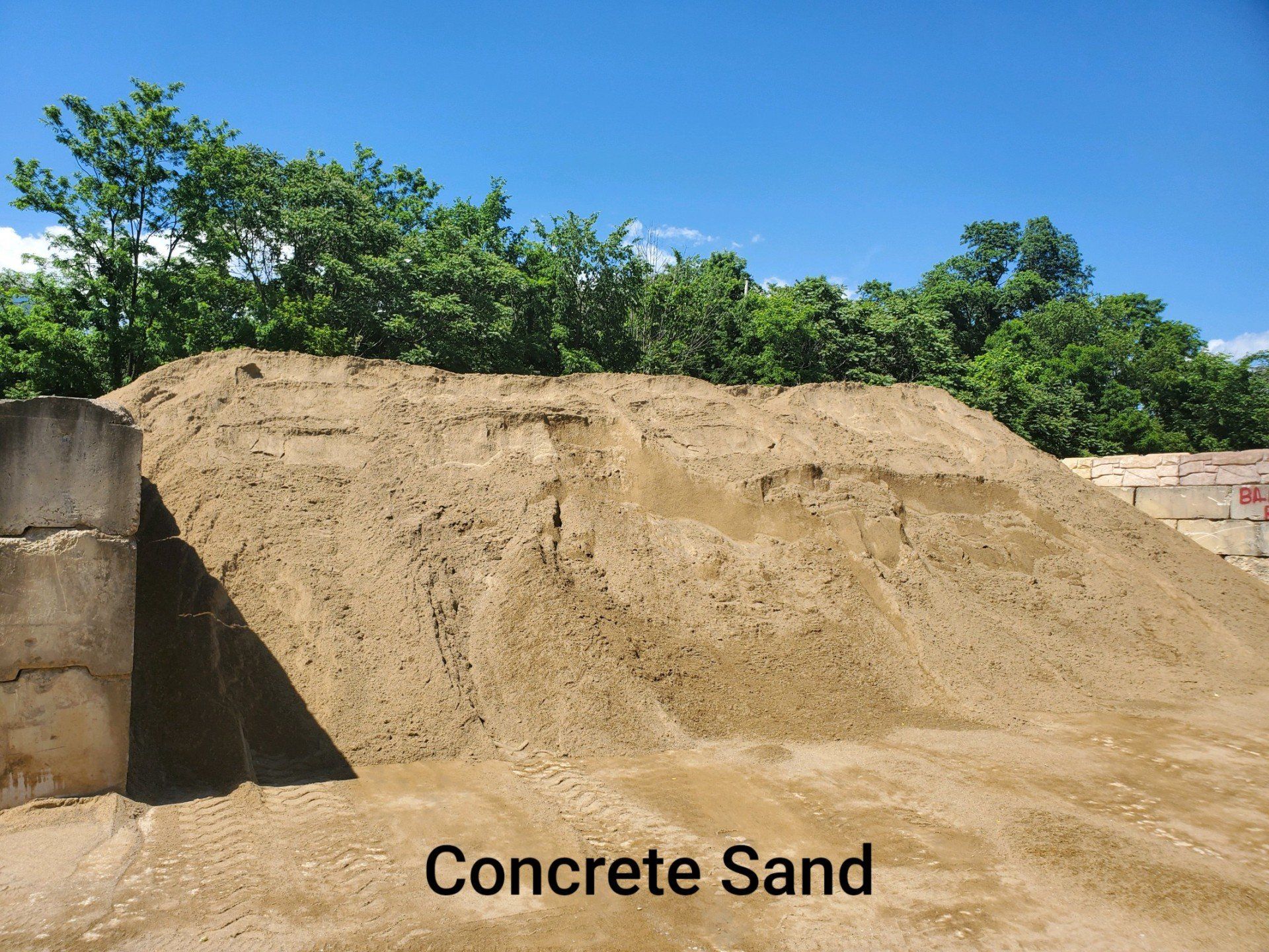 A pile of concrete sand with trees in the background