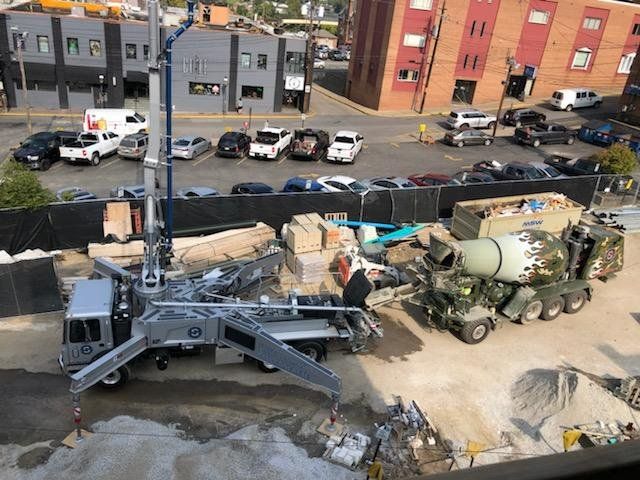 An aerial view of a construction site with a concrete mixer in the foreground