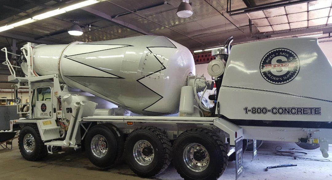 A concrete mixer truck is parked in a garage.