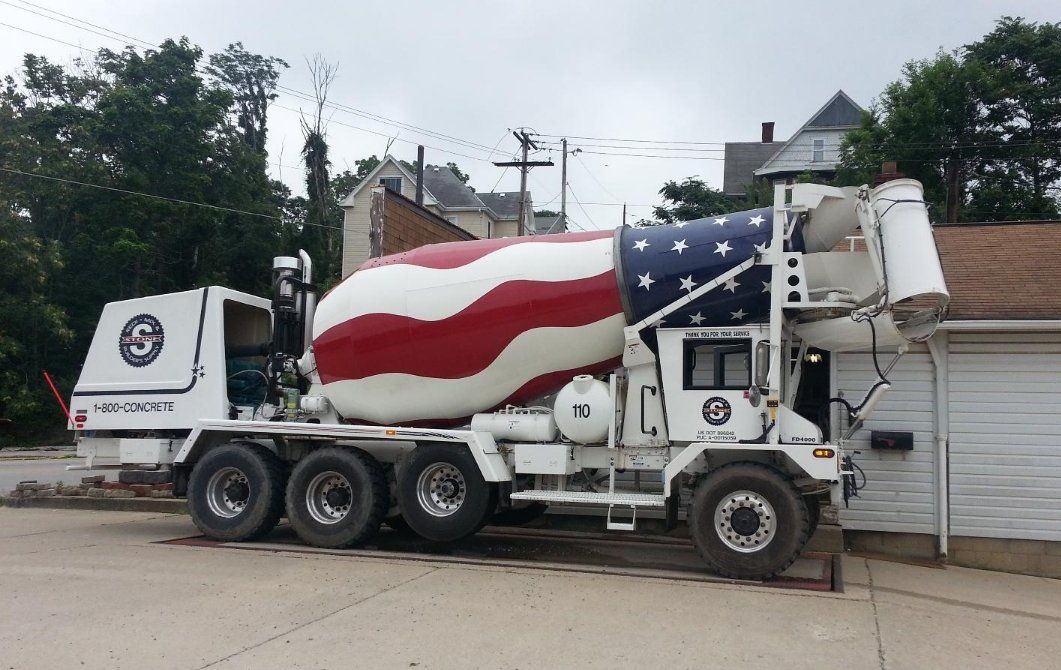 A concrete mixer truck with an american flag painted on it