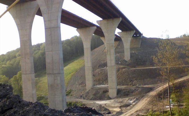 A bridge is being built over a dirt road