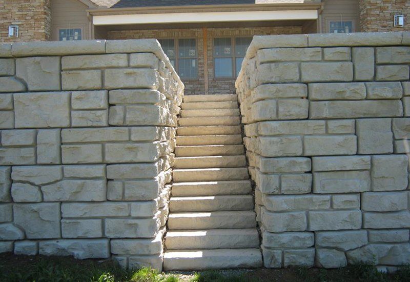 A stone wall with stairs leading up to a house
