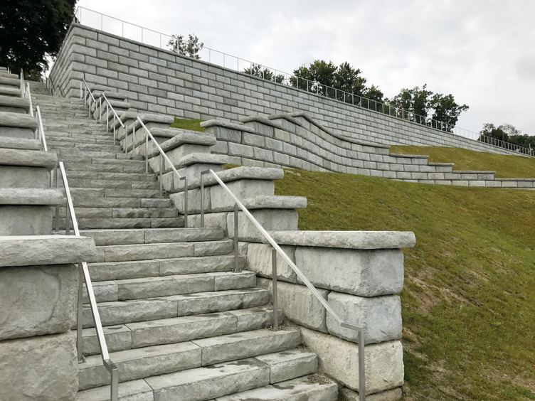 A set of stairs leading up to a hill with a railing.