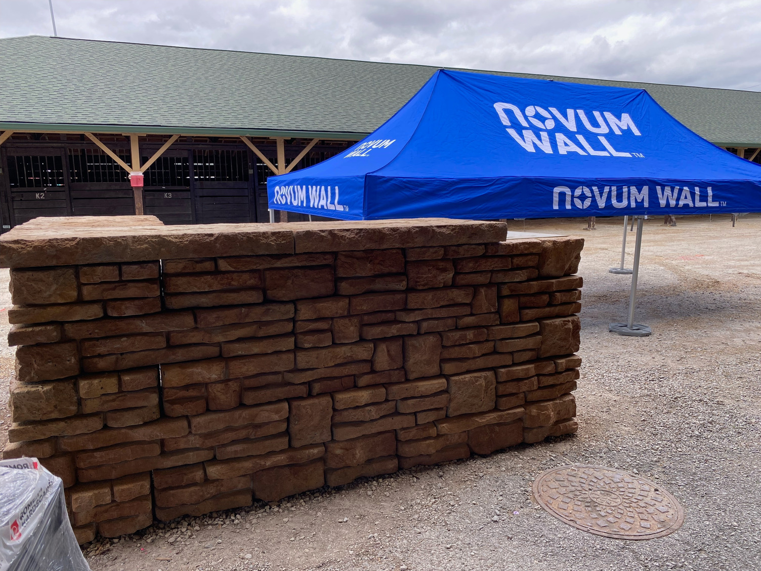 A blue novam wall tent is sitting next to a brick wall.
