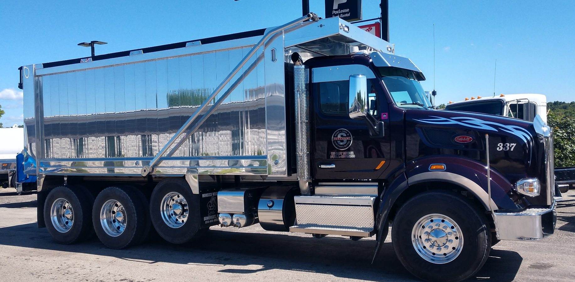 A black dump truck is parked in a parking lot.