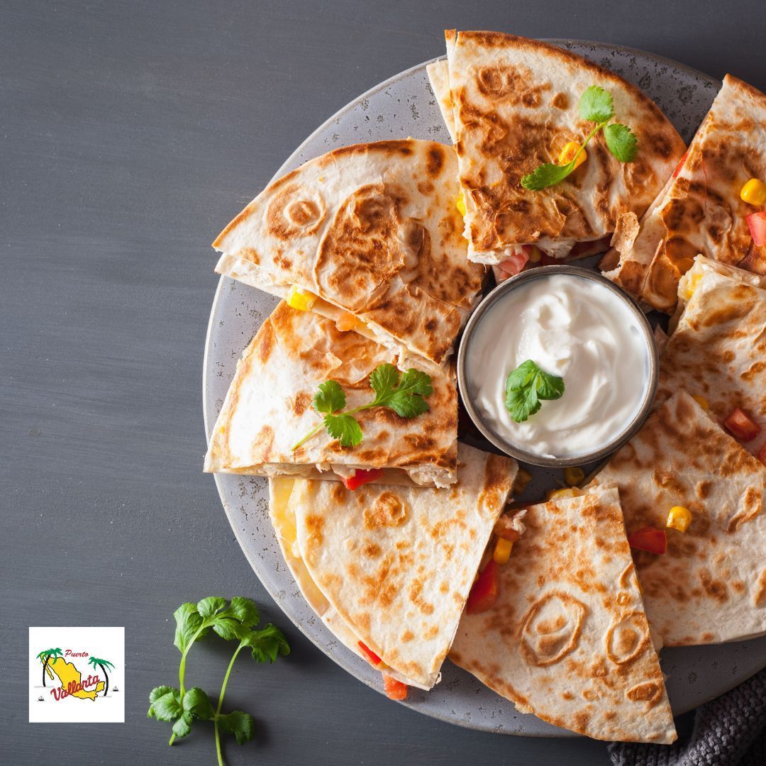 A plate of quesadillas with sour cream on top.