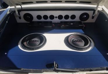 The trunk of a car has two speakers in it
