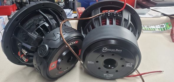 Two subwoofers are sitting next to each other on a table