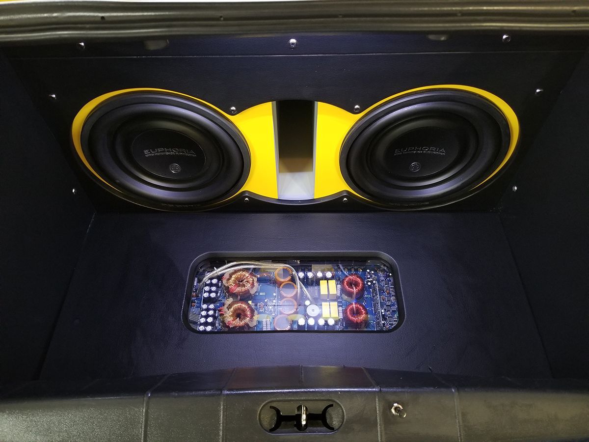 A black car with yellow speakers in the trunk