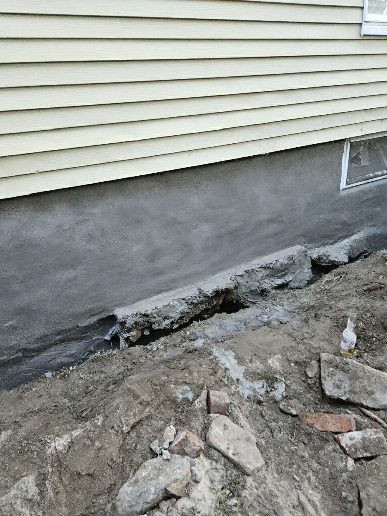 A house with a hole in the ground in front of it.