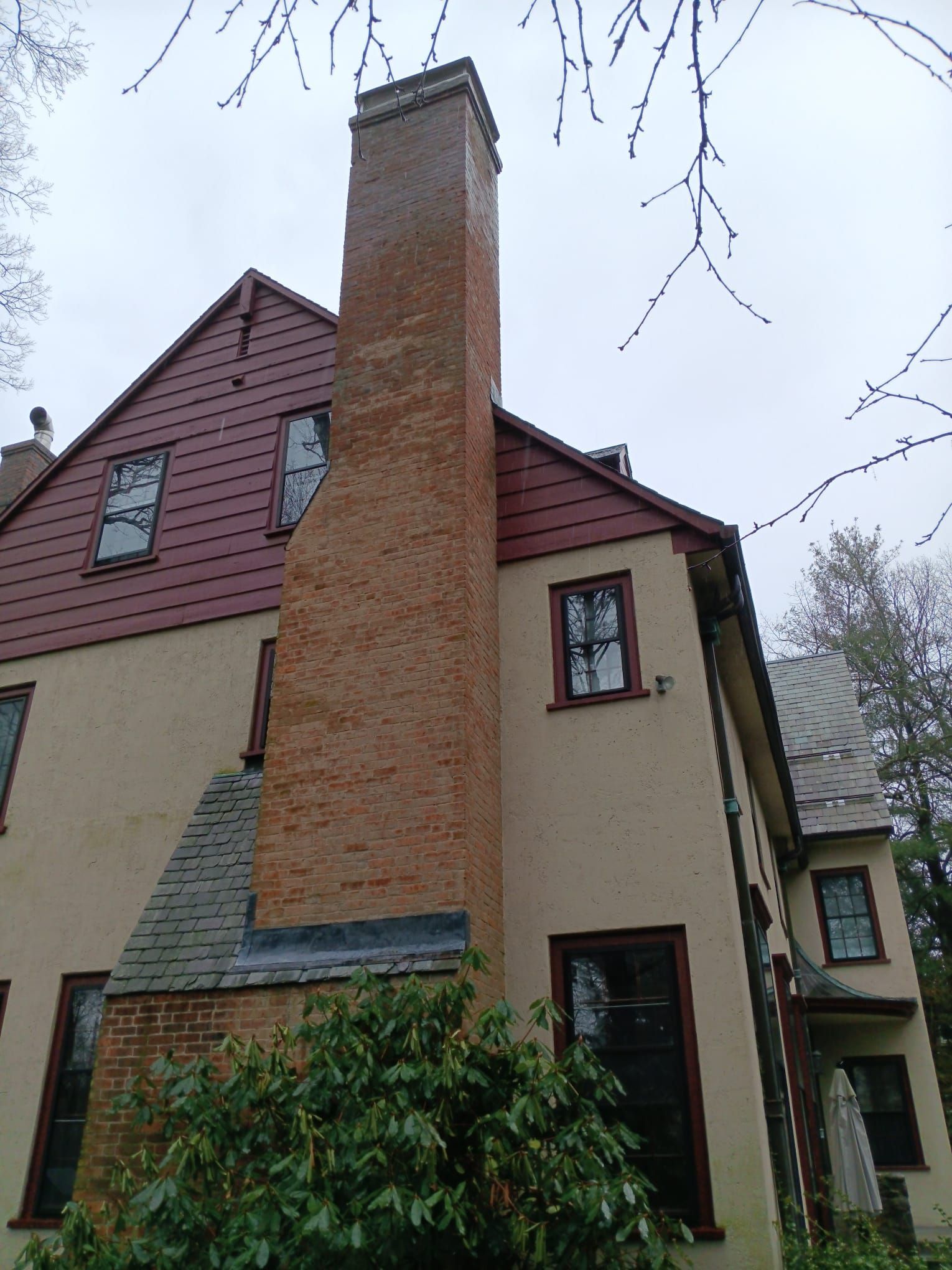 A large brick chimney is on the side of a house.