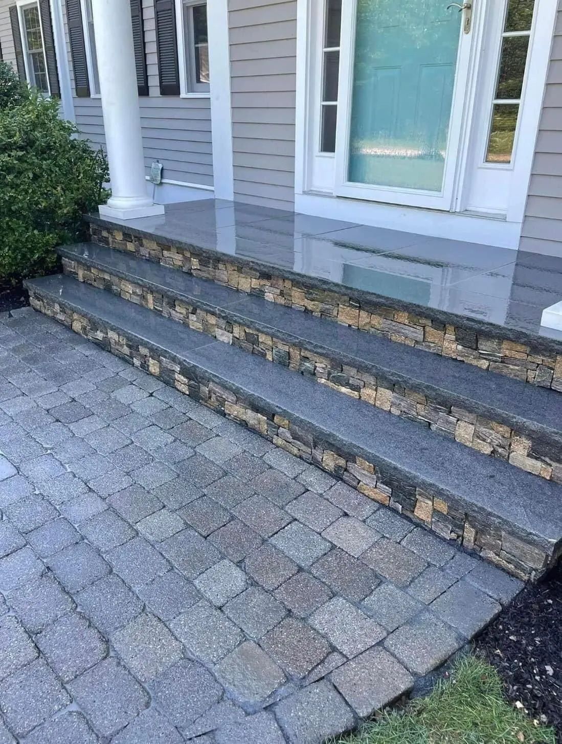 A stone porch with steps leading up to a house.