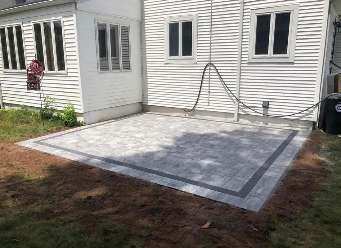 A patio is being built in the backyard of a house.