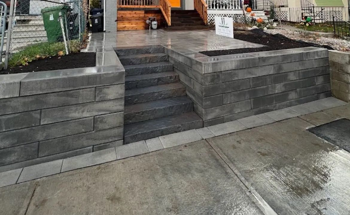 A brick wall with stairs leading up to a house.