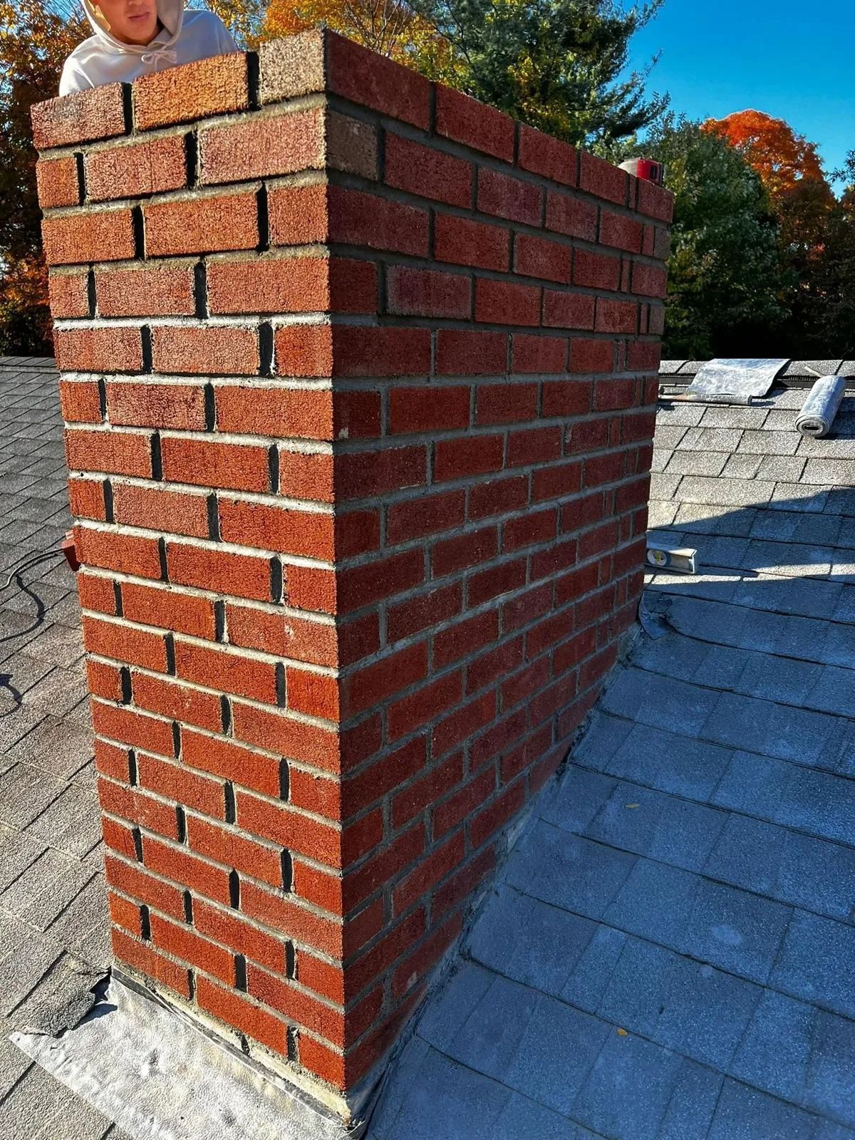 A brick chimney is sitting on top of a roof.