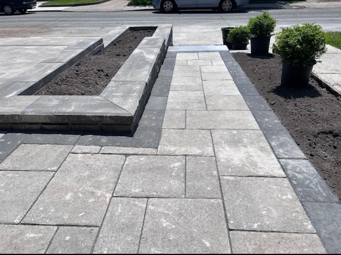 A car is parked on the side of the road next to a brick walkway