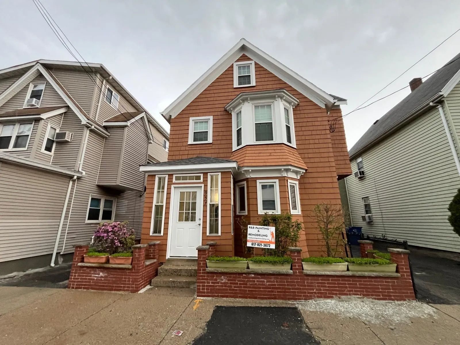 A brick house with a for sale sign in front of it