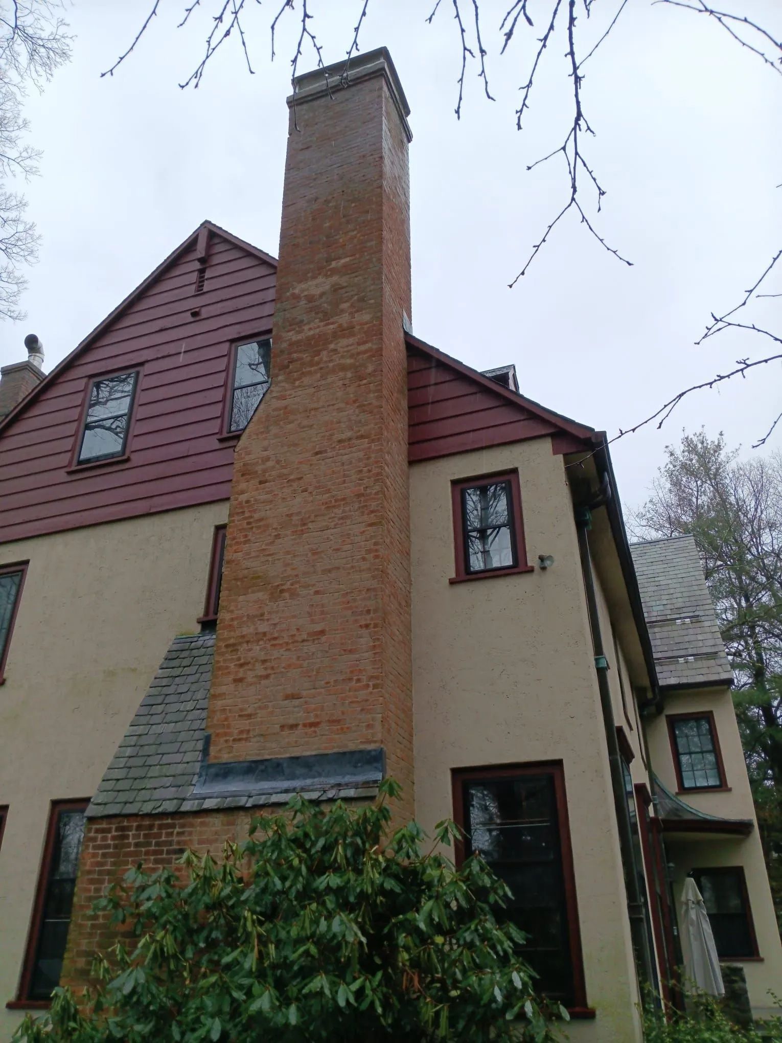 A large brick chimney is on the side of a house.
