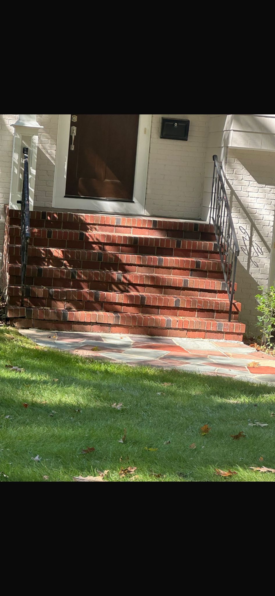 A set of brick stairs leading up to the front door of a house.