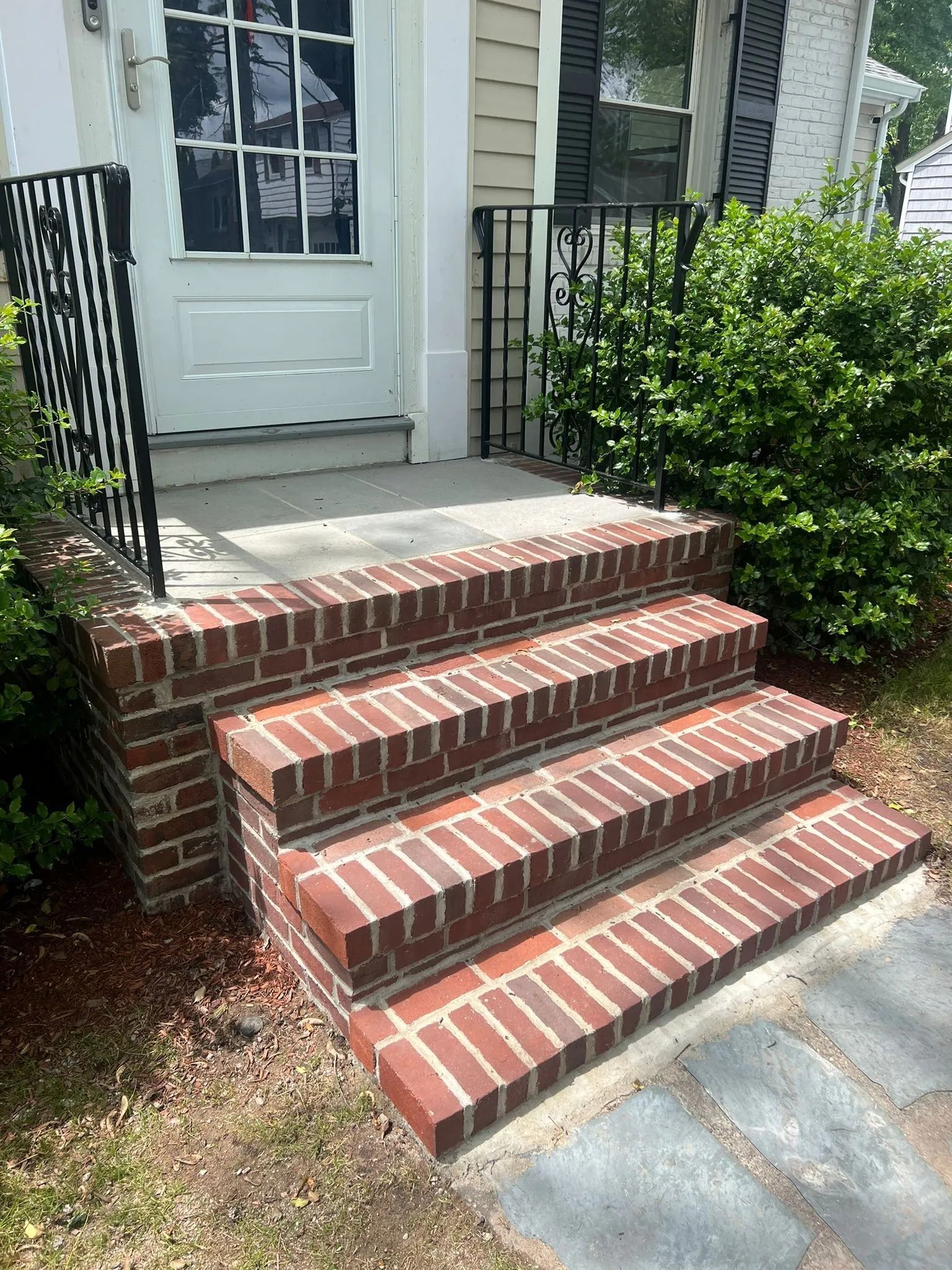 There are stairs leading up to the front of a house.