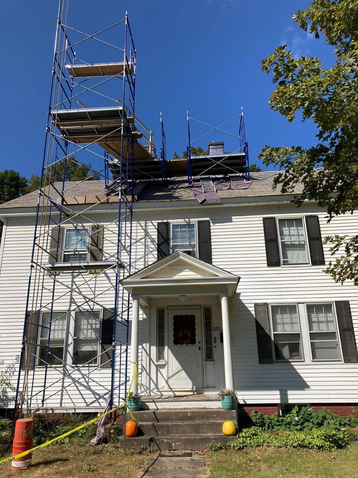 A white house with a scaffolding on top of it.