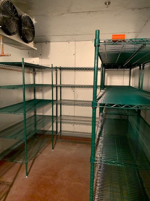 Interior view of a commercial walk-in cooler with green wire shelving.