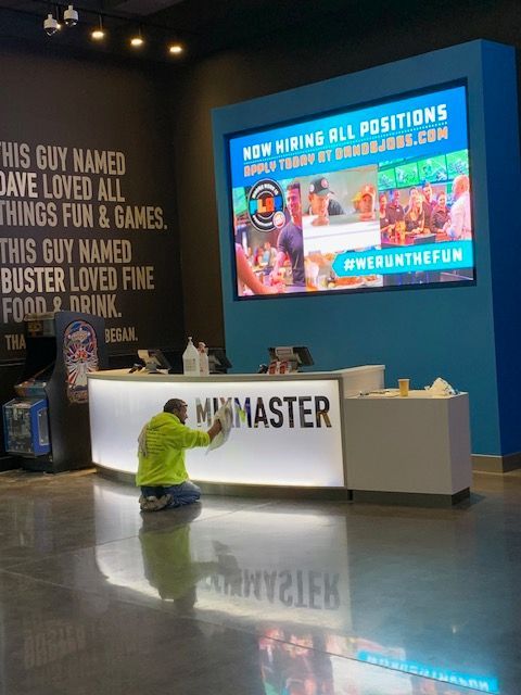 A person cleaning a reception desk labeled 