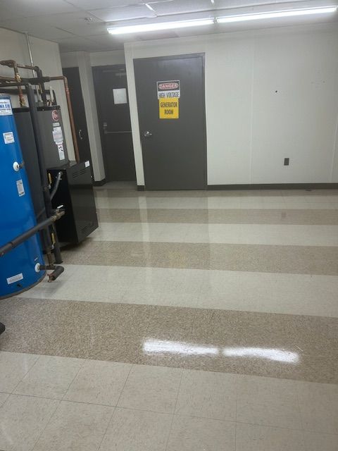 Empty utility room with water heater and doors. Light floor with two-tone stripes.