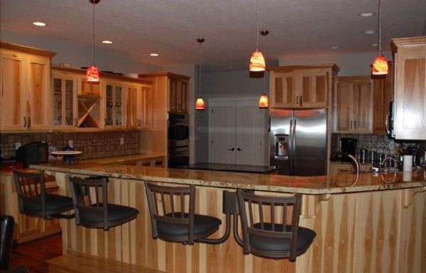 Modern kitchen with wood cabinets, breakfast bar stools, and pendant lights
