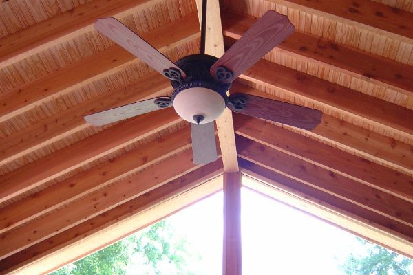 Ceiling fan mounted on a wooden vaulted porch ceiling, viewed from below
