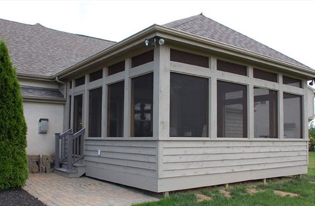 Screened porch with gray siding and windows on a house