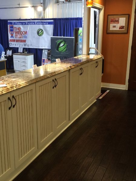 Hotel registration counter with cream cabinets, dark floor, and blue-curtained booth in the background
