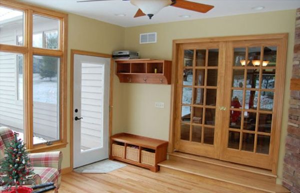 Bright sunroom with wood floors, ceiling fan, bay windows, and built-in wood cabinets and bench seating