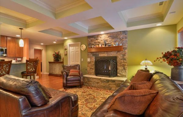 Cozy living room with leather chairs, brick fireplace, warm lighting, and patterned rug.
