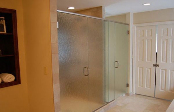Bathroom with frosted glass shower enclosure and white double doors.