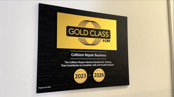 A black and gold I-CAR Gold Class sign on a wall, showing industry training recognition for 2023 and 2025.