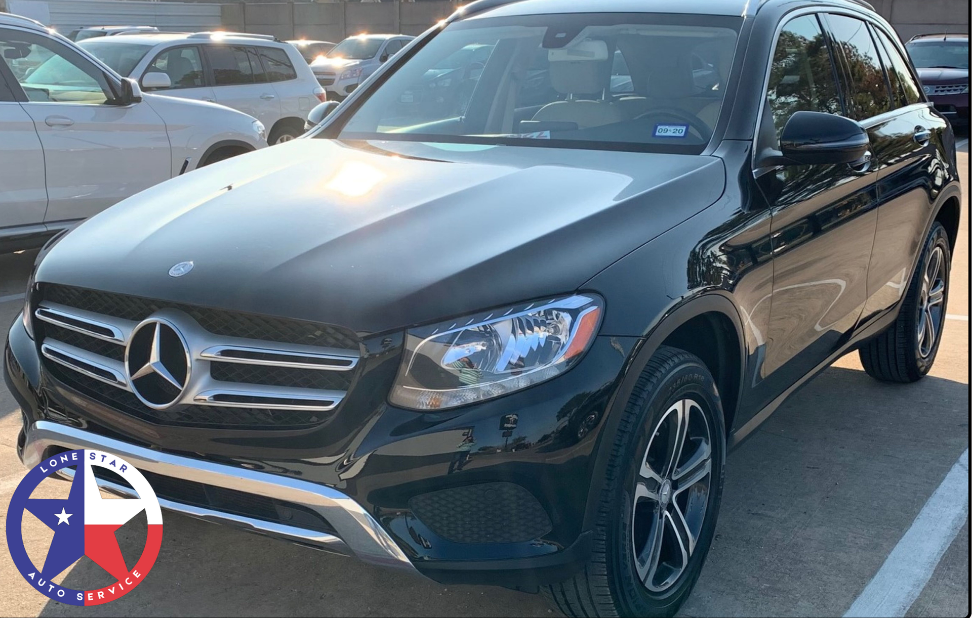 A black Mercedes-Benz SUV parked in an outdoor lot on a sunny day.