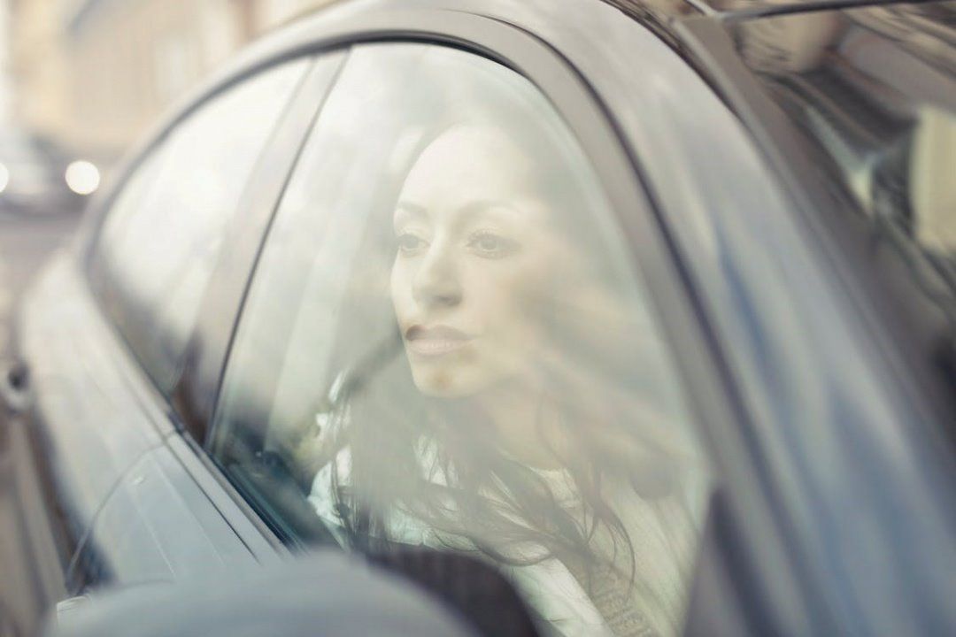 Woman inside her car looking out on her car's window