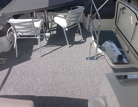 A boat with a table and chairs on the deck