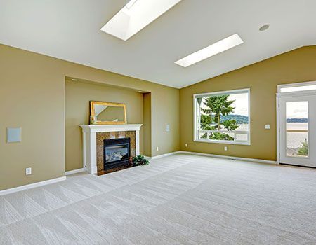 A living room with a large sectional couch and a rug.