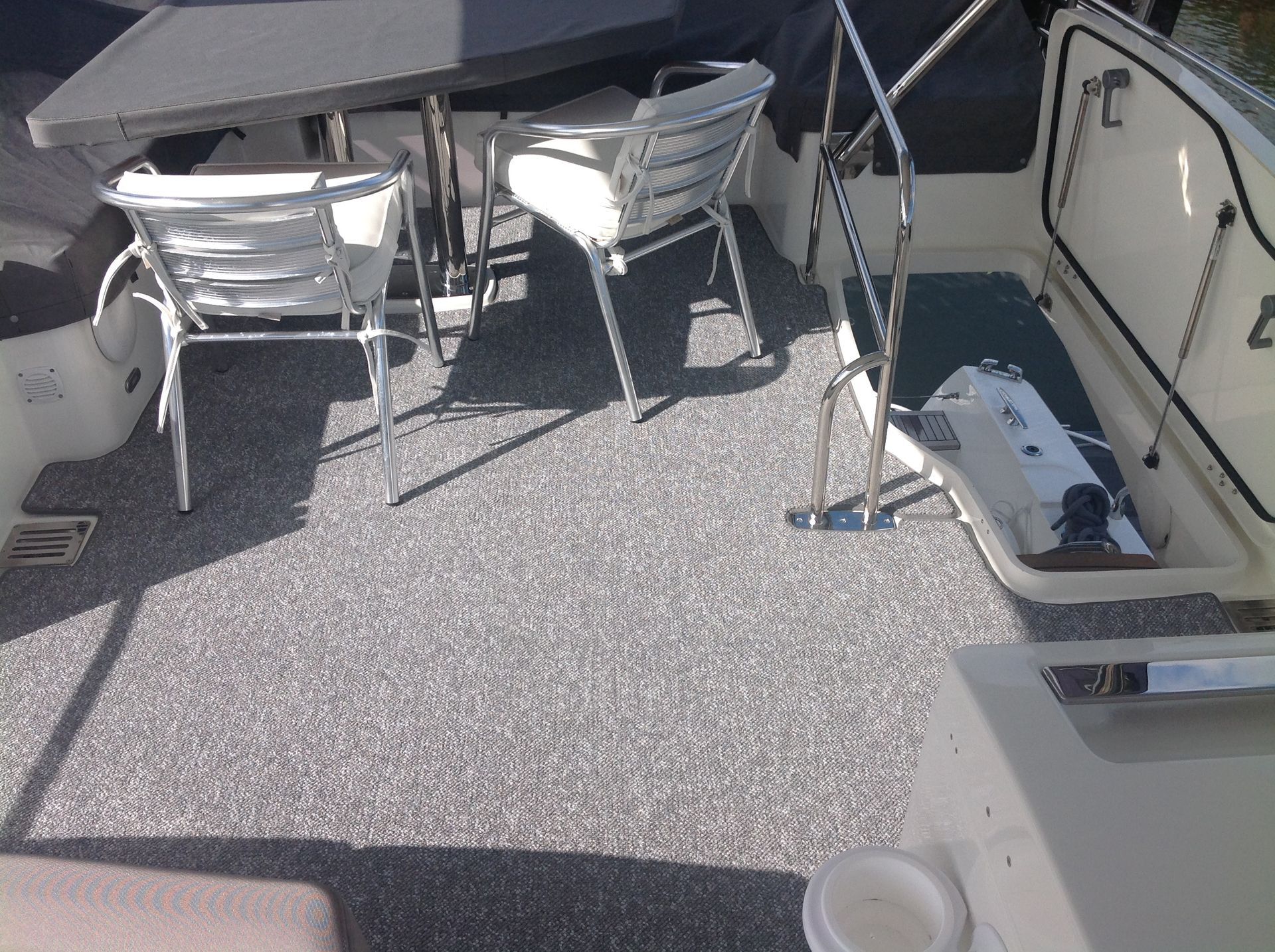 A boat with a table and chairs on the deck